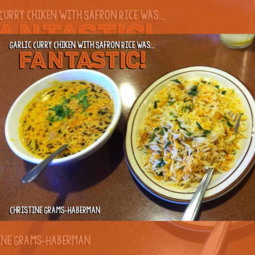 A digital screen displaying an advertisement for food with the message "YUM" and promoting the restaurant.