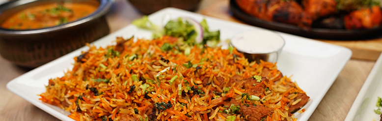 A vibrant and colorful bowl of chicken biryani with toppings