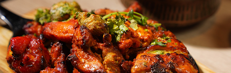 Close-up of a spicy chicken curry dish in a bowl.