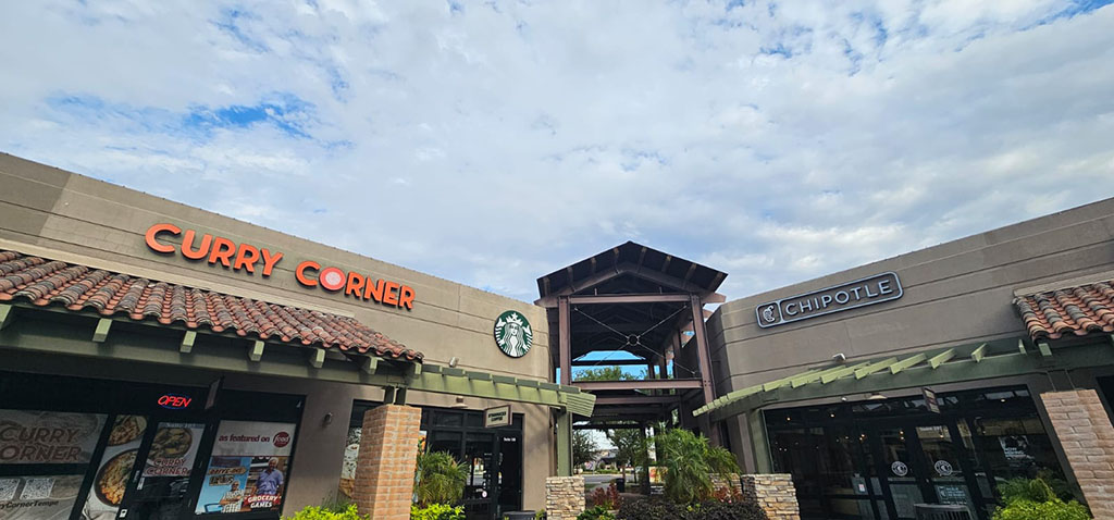 Exterior of a shopping center with Curry Corner, Starbucks, and Chipotle storefronts